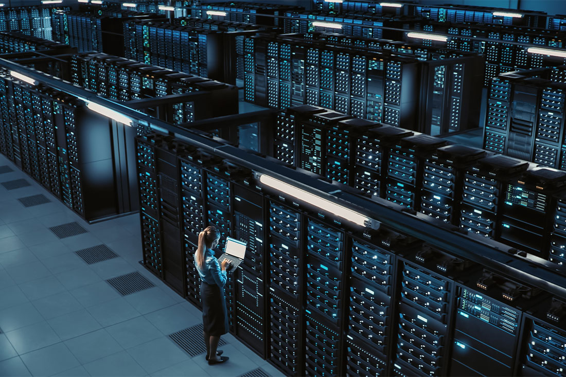 Woman using laptop in data center using laptop