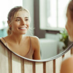 Woman smiling in the mirror practicing positive self talk